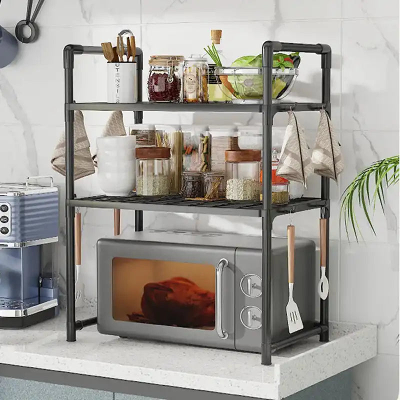 Black 3-tier microwave shelf with spice jars, utensils, and hanging hooks, perfect for space-saving kitchen storage and organization.