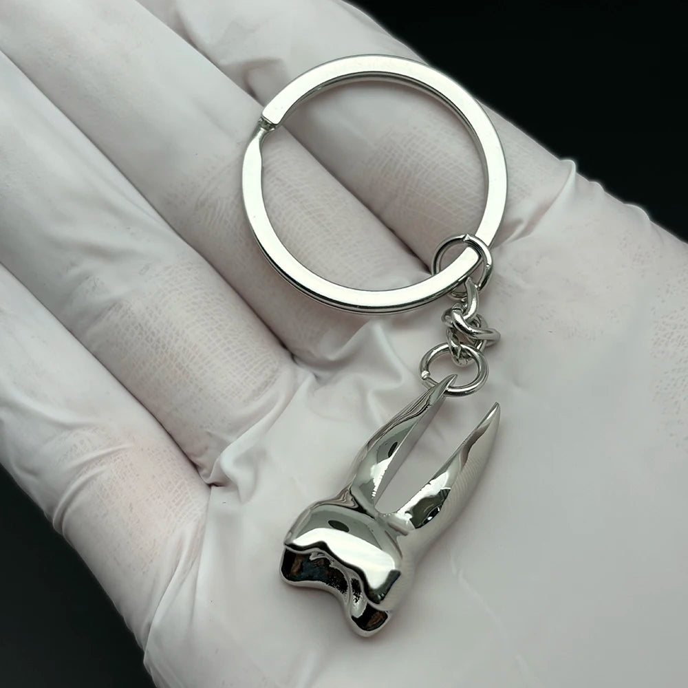 Shiny silver molar tooth keychain charm, a unique dentist gift or dental hygiene accessory for boys, girls, or dental professionals.