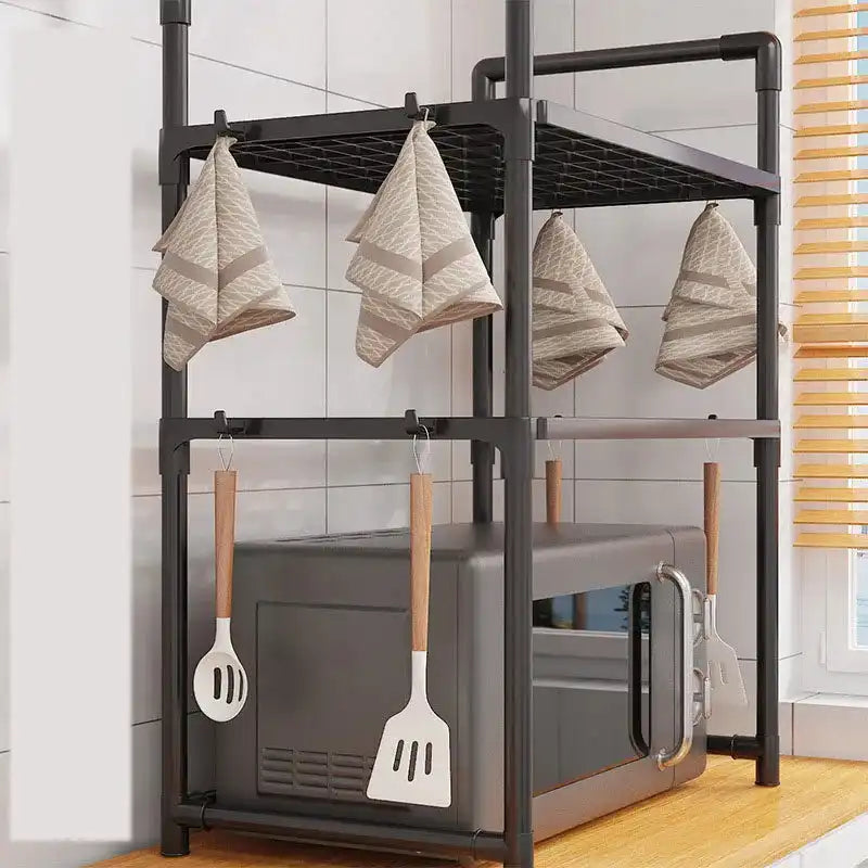 Compact black kitchen organizer rack with towel hooks and utensil holders, designed for microwave storage and countertop efficiency.