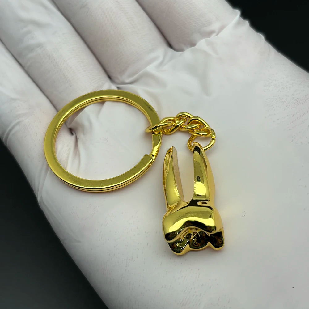 Gold tooth-shaped keychain charm, perfect dentist gift or dental-themed accessory for moms, kids, or dental school graduates.