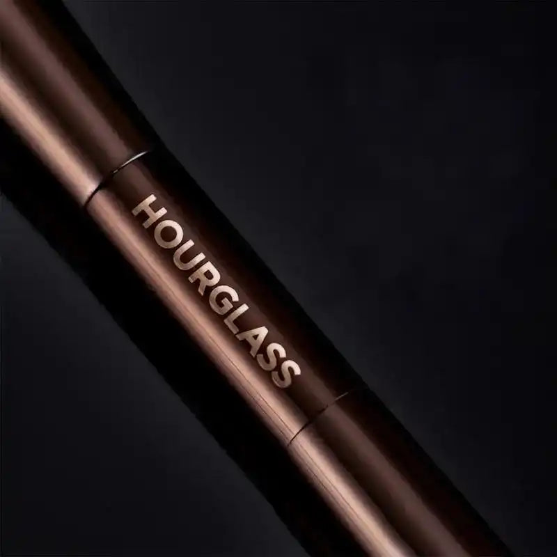 Close-up of the Hourglass logo on the sleek, professional metal handle of the dual-ended makeup brush.
