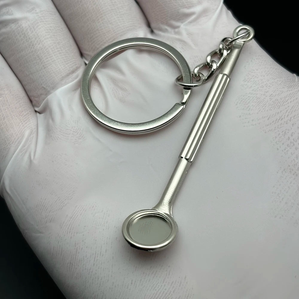 Metal dental mirror keychain charm, compact and stylish dentist gift or dental-themed keyring for hygiene professionals and students.