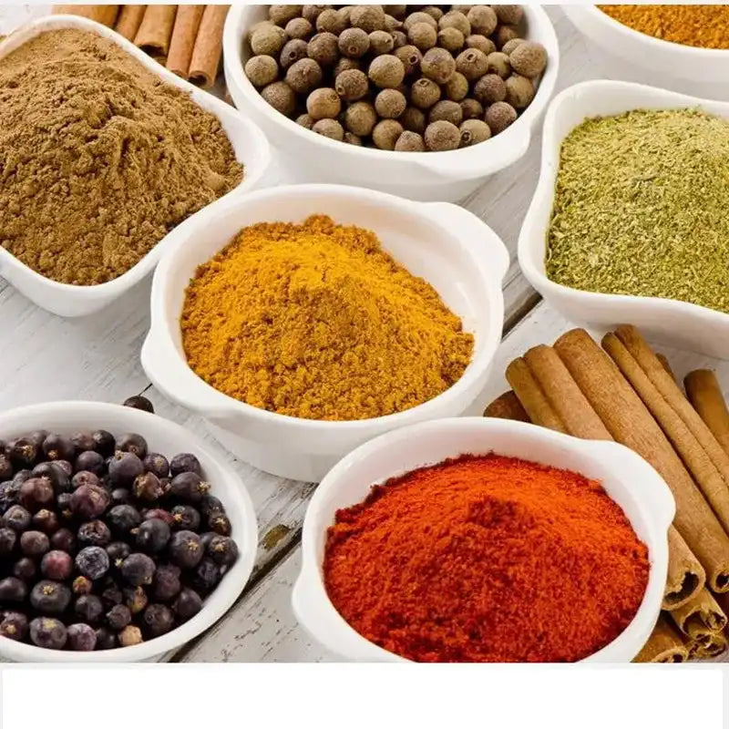 Assorted ground spices in white bowls for cooking