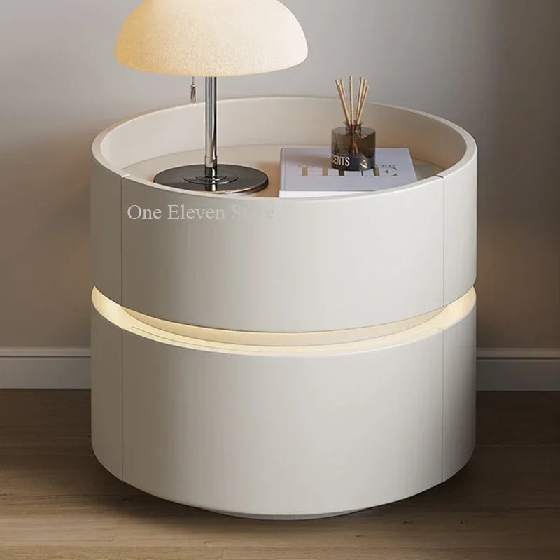 Modern white bedside table with built-in LED lighting and a table lamp
