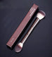 Makeup brush with double-head design and professional metal handle, shown with branded box for blush and loose powder application.
