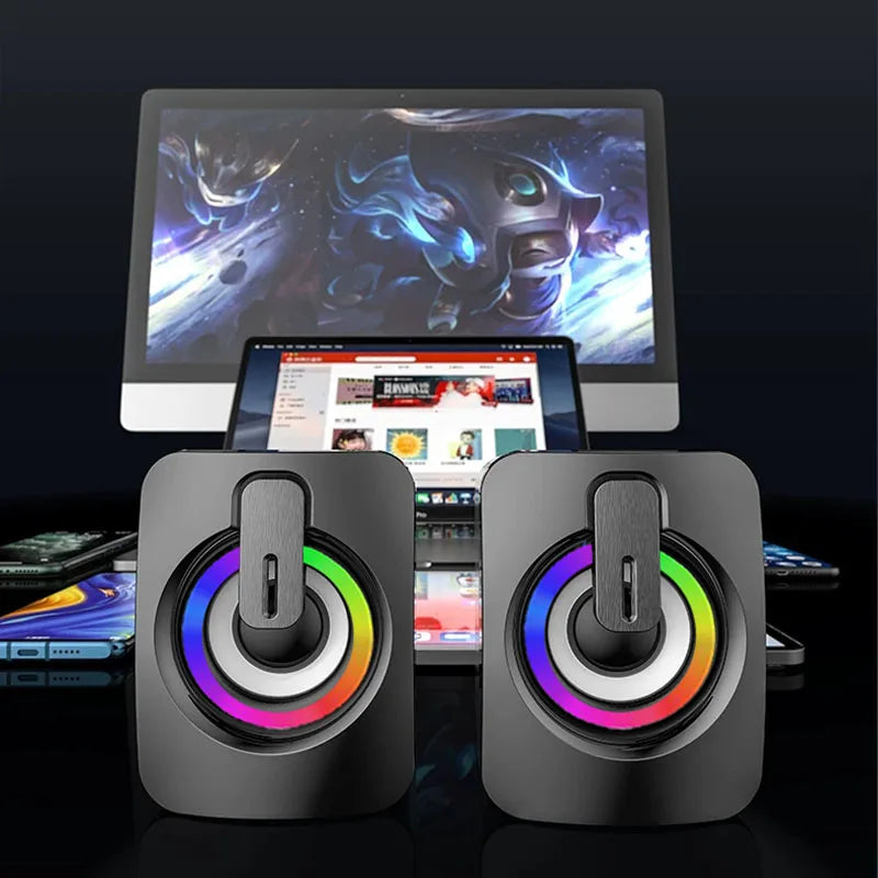 USB wired desktop computer speakers with LED lights, shown with multiple devices including PC and smartphones.
