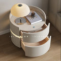 Modern white bedside table with drawers, table lamp, book, and decorative items in bedroom