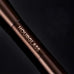 Close-up of the Hourglass logo on the sleek, professional metal handle of the dual-ended makeup brush.