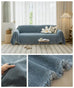Blue solid sofa towel cover with textured knit and tassel edge, non-slip and machine washable for recliners, loveseats, or futon sofas.