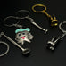Close-up of assorted dental hygiene keychains including a cartoon tooth, dental tools, and molar charms in silver and gold finishes.